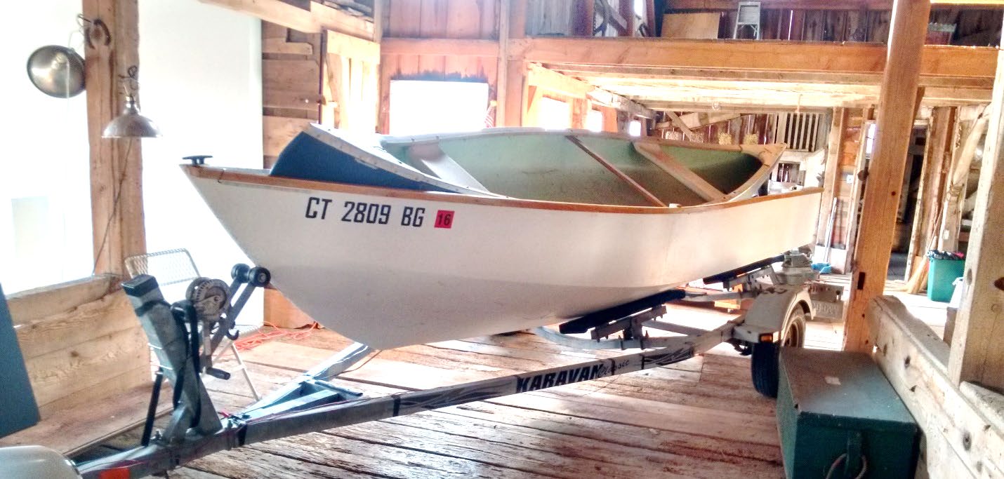Completed boat stored on its trailer, holding a canoe